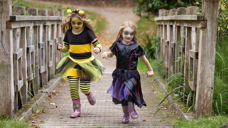 Children in fancy dress running in garden at Ightham Mote, Kent